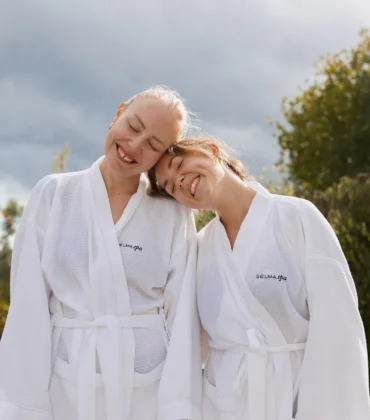 Höstspapaket på Selma Spa – två kvinnor i badrockar njuter utomhus